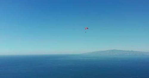 Extremer Gleitschirm, der vor einem klaren blauen Himmel fliegt