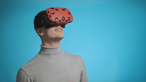 Young Adult Using VR Headset on Blue Background