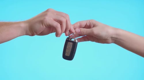 Close Up Cropped Man Woman Hands Present Give Each Other Gift Car Keys Isolated on Pastel Blue