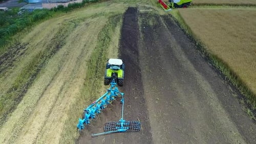 Tractor Plows The Field. Tractor with cultivator handles field before planting