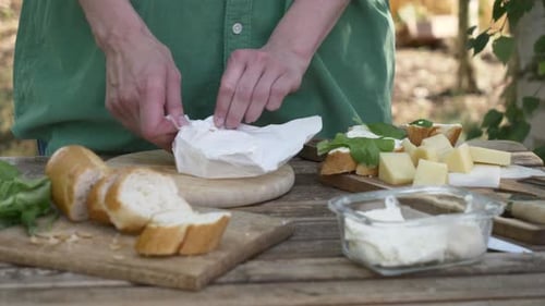 Preparing Bread and Cheese Platter Outdoors