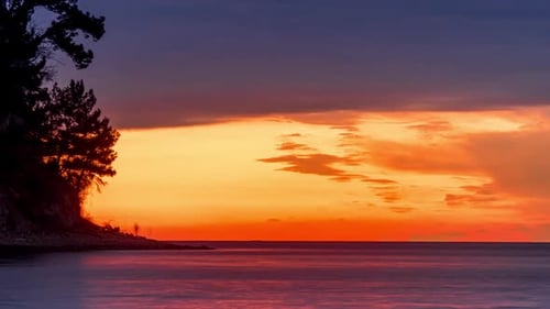 People on the sea beach against the sunset sky