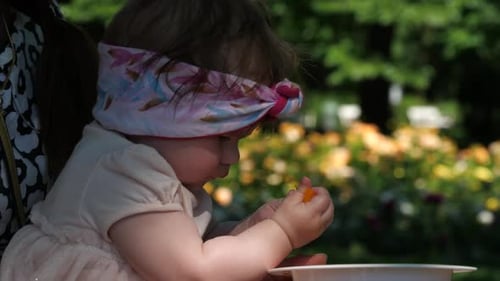 Baby Eating Vegetables in Sunny Garden