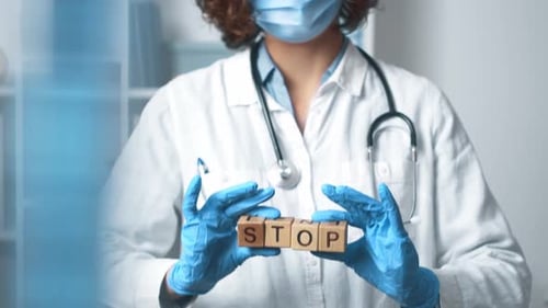 Medical Professional Displays 'STOP' Blocks Indoors