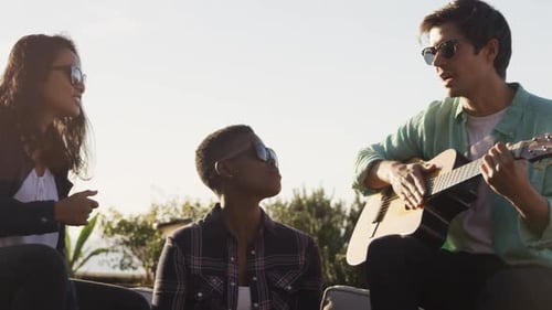 Friends Sing and Play Guitar Outside Together