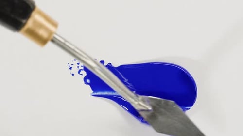 Bright Blue Paint Spread with Spatula on White