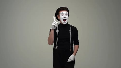Portrait d'un mime masculin joyeux et réfléchi réfléchit à se gratter la tête en se touchant la main au menton