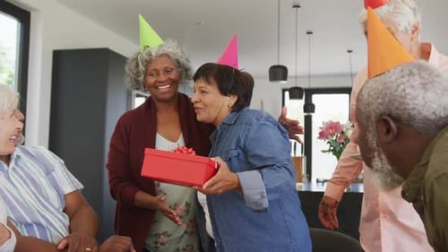 Mature Adult Friends Celebrating Birthday with Cupcakes and Gifts