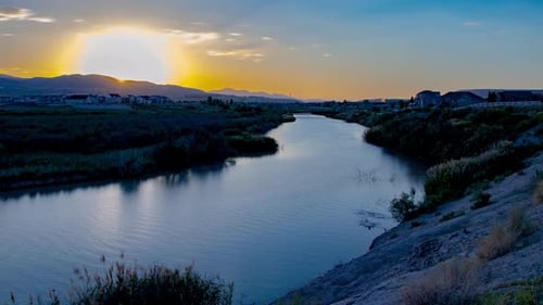 Time-lapse statique d'une belle rivière et d'un paysage au coucher du soleil alors que la scène passe à la nuit