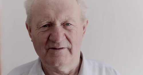 Close Portrait of Handsome Senior Man with Gray Hair Looking Into Camera
