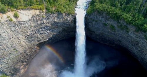 Beautiful water fall through forest cliff on a sunny day