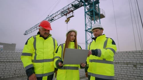 Team of Architect Civil Engineer and Foreman in Construction Site Woman is Holding Laptop with