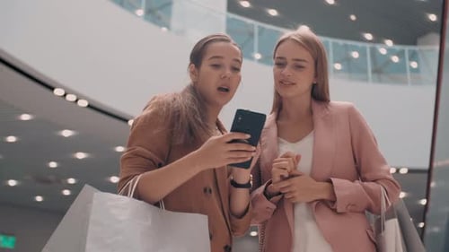 Friends Look at Phone and Shopping in Mall