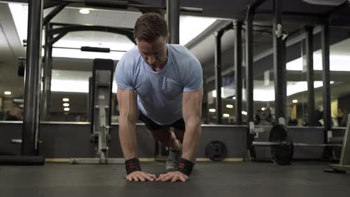 Image of an attractive man doing push-up at the gym.