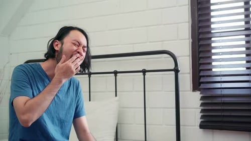 Sleepy Man Waking Up and Stretching Indoors