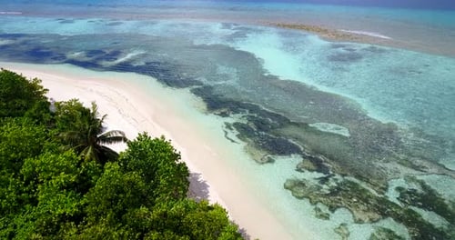 Natural flying tourism shot of a white paradise beach and blue sea background in best quality 4K