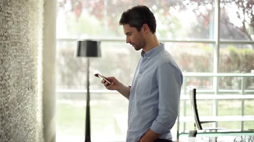 Man Uses Mobile Phone in Bright Home