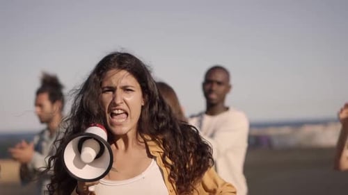 Woman Leads Protest with Megaphone and Raised Hands