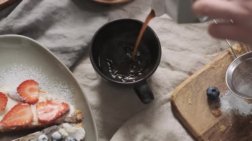 Woman or Girl in Beige Apron Serves Table at Home or in Restaurant and Pouring Coffee in Cup From