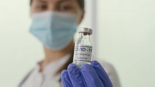 Closeup a Vial with the COVID19 Coronavirus Vaccine in the Hand of a Doctor
