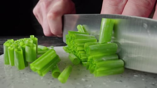 Green Onion are Cut with Knife in Kitchen