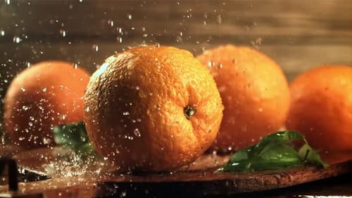 Gotas de agua caen sobre naranjas frescas