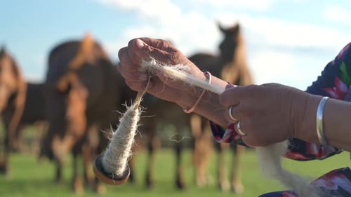 Person Winds White Material in Rural Setting