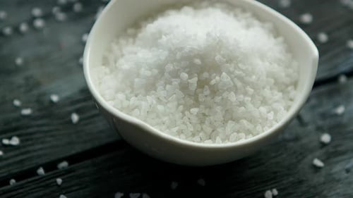 Bowl of Coarse Sea Salt Crystals on Wood
