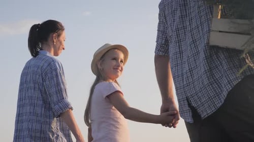 Happy Family Concept. Young Family Having Fun Outdoors in Their Farm. Gardener Woman Pushing