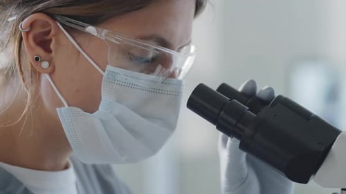 Female Lab Worker Using Microscope