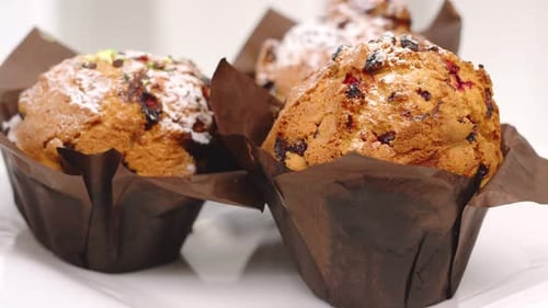 Close Up Fresh Muffins with Raisins Covered By Powdered Sugar Rotating