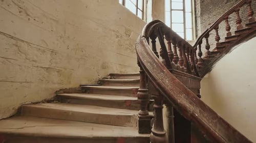 A Staircase with Wooden Railing in an Abandoned Architectural Building