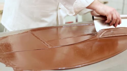 Pastry chef at work tempering chocolate in a restaurant kitchen
