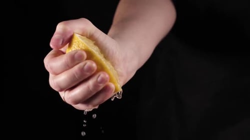 Hand Squeezing a Lemon Half Close Up