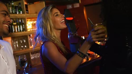 Friends Embracing, Cheering, and Drinking at a Bar