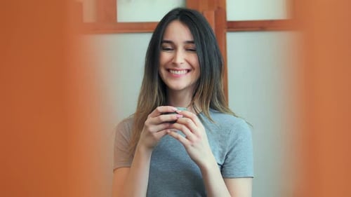 Young Woman Drinking Tea and Relaxing in Cafe