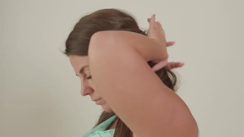 Woman Touches Face, Hair in Close Up