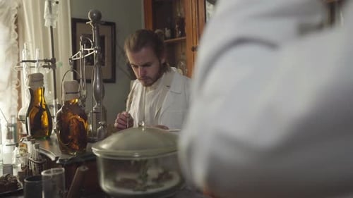 Young Concentrated Man Checking Medicines in Ancient Pharmacy, Guy Writing with Feather Pen
