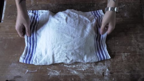 Frische Brotkuchen Kneten Sie mit einem Tuch bedeckte Teigkugeln über das Holz