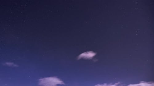 Nachthimmel mit sich drehenden Sternen. Kleine Wolken bilden sich