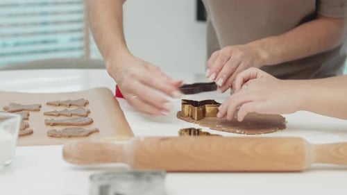 Child and Adult Making Christmas Cookies at Home