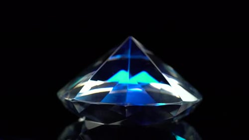 Diamant dreht sich und schimmert mit dunkelblauer Farbe, schwarzem Hintergrund