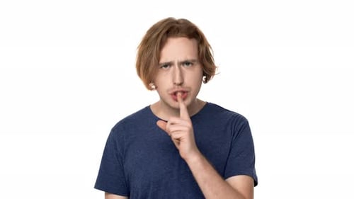 Porträt eines unrasierten Mannes, der mit strengem Blick posiert und bittet: Bleib ruhig und legt den Zeigefinger auf die Lippen