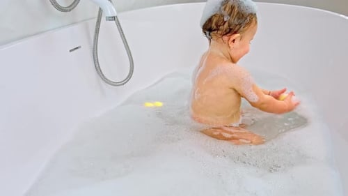 Baby Enjoys Bath Time Playing with Duck