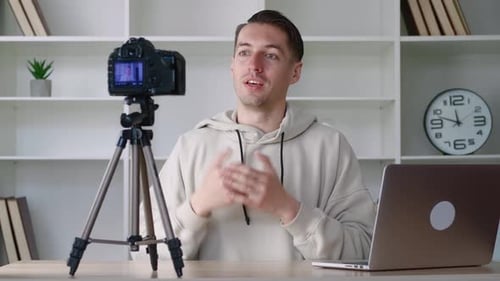 Young Blogger Man Filming New Vlog Video with Professional Camera at Workplace at Office
