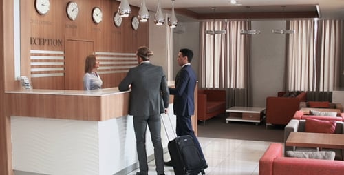 Businessmen Checking in at Modern Hotel Reception