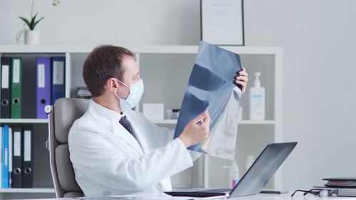 Professional medical doctor working in hospital office using computer technology.
