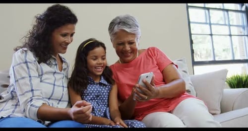 Multi-Generational Family Looking at Smartphone Together Indoors