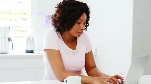 Woman Working on Laptop in Bright Kitchen