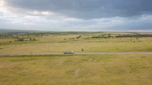 Trucks Traveling on Rural Road in Vast Landscape